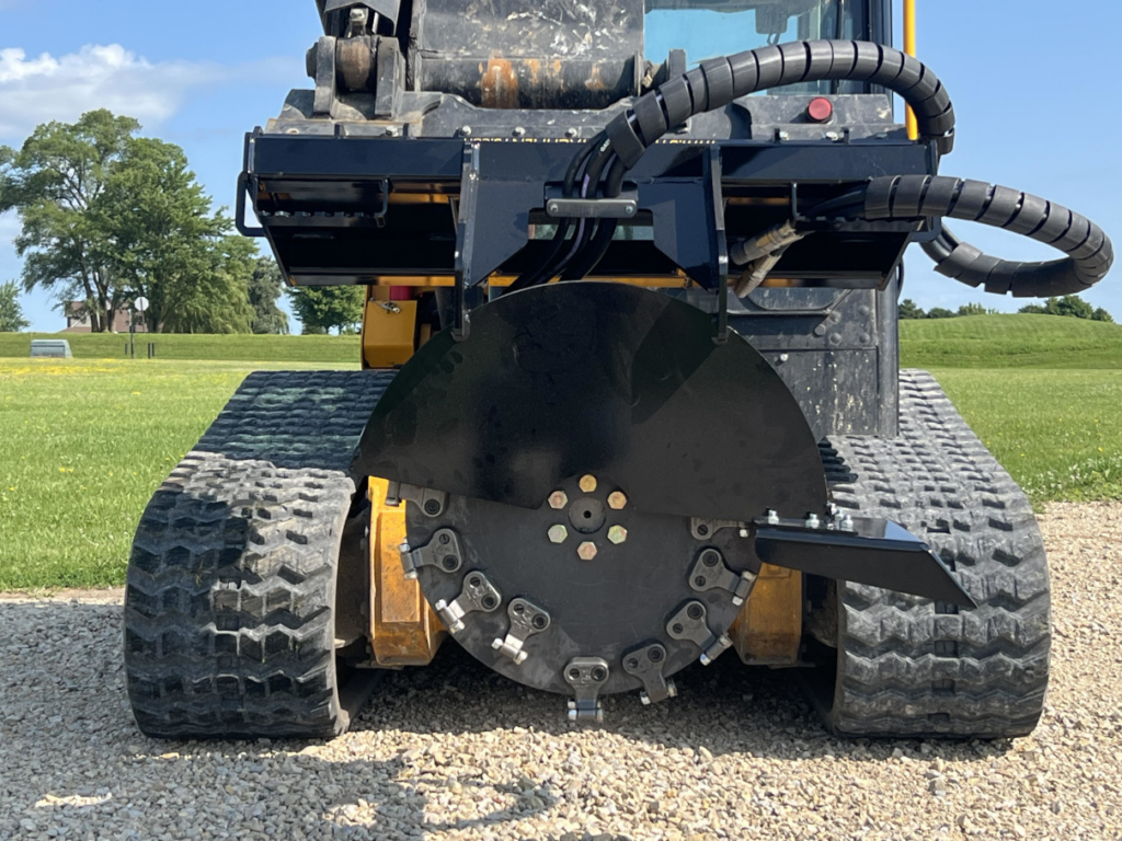 Front close-up of the Stinger skid steer stump grinder cutting wheel with carbide teeth and protective guard