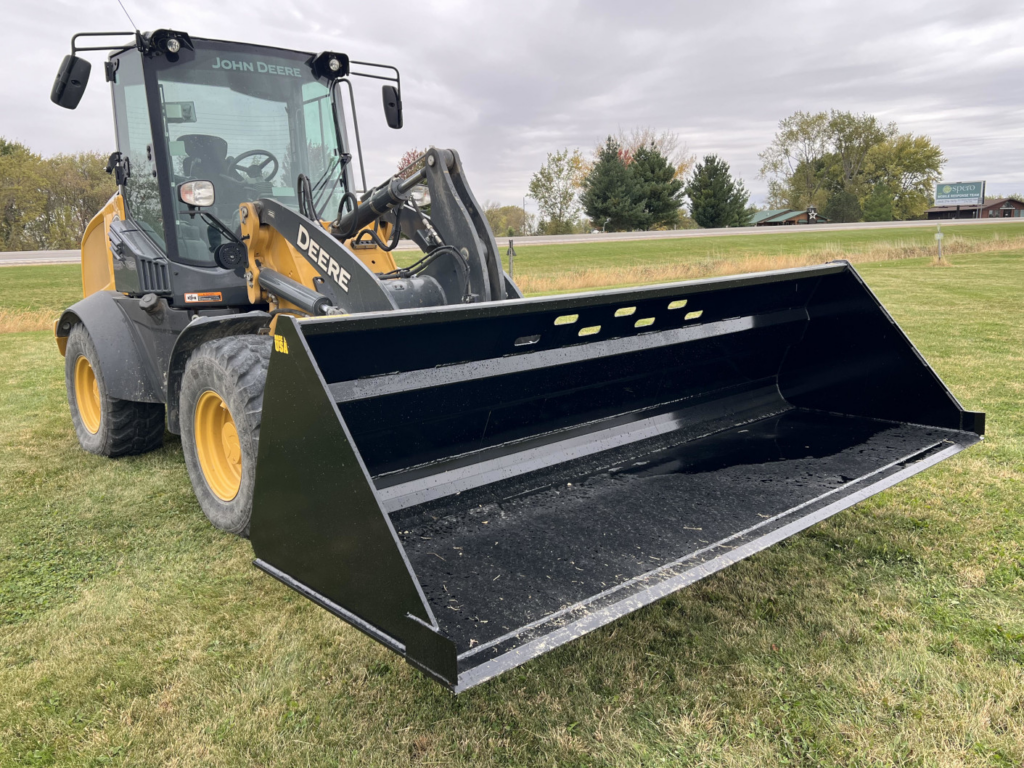 Front angled view of the Stinger SNB Wheel Loader Snow Bucket mounted on a John Deere wheel loader
