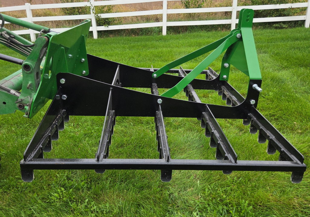 Side profile of the SWAT Metal Works 72" Compact Land Rake showing the open steel frame and multiple ground-engaging tooth rows.
