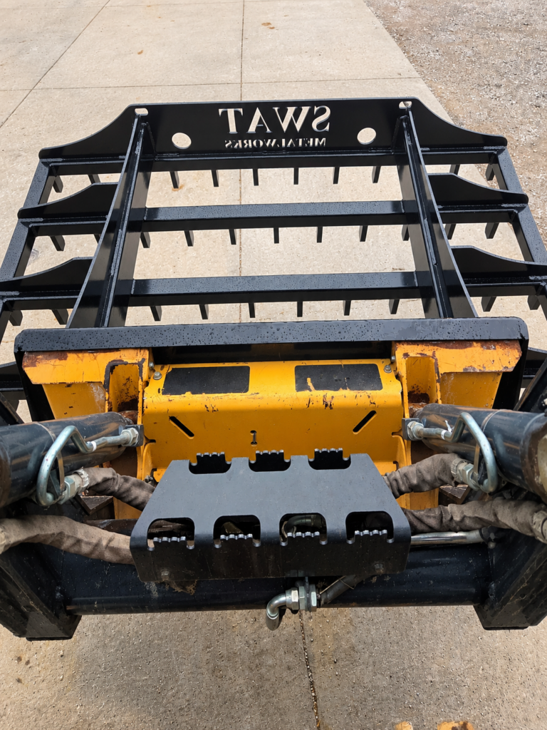 Rear view of the SWAT Metal Works Skid Steer Land Rake mounted to a John Deere skid steer